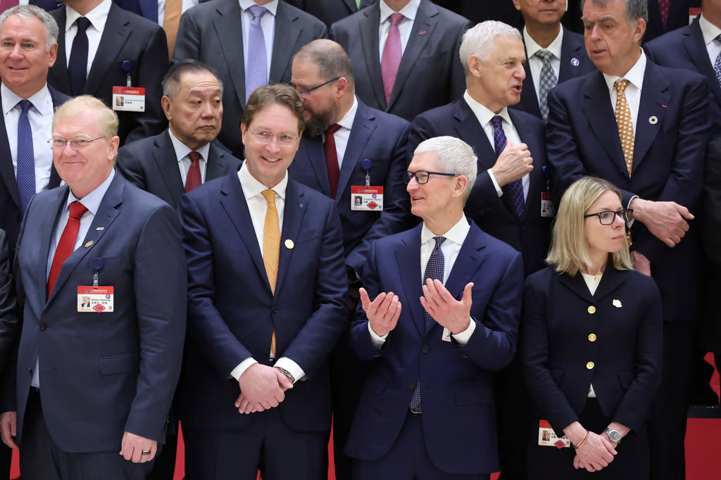 Tim Cook s'entretient avec d'autres participants avant la cérémonie d'ouverture du Forum sur le développement de la Chine à Pékin.