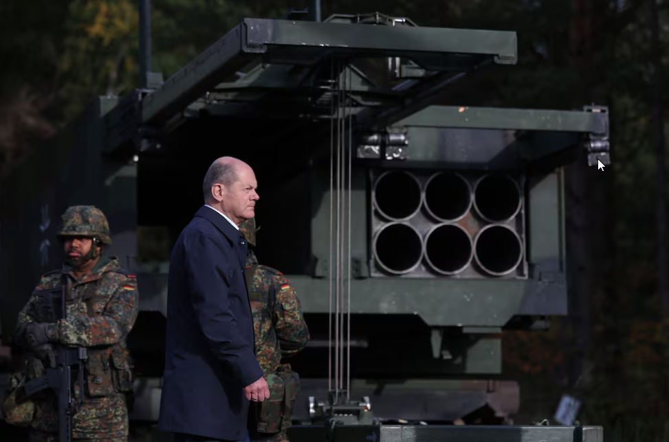 Le chancelier allemand Olaf Scholz passe devant le système de fusées à lancement multiple (MARS II). Illustration : AFP Le chancelier allemand Olaf Scholz à côté du système de fusées à lancement multiple (MARS II)